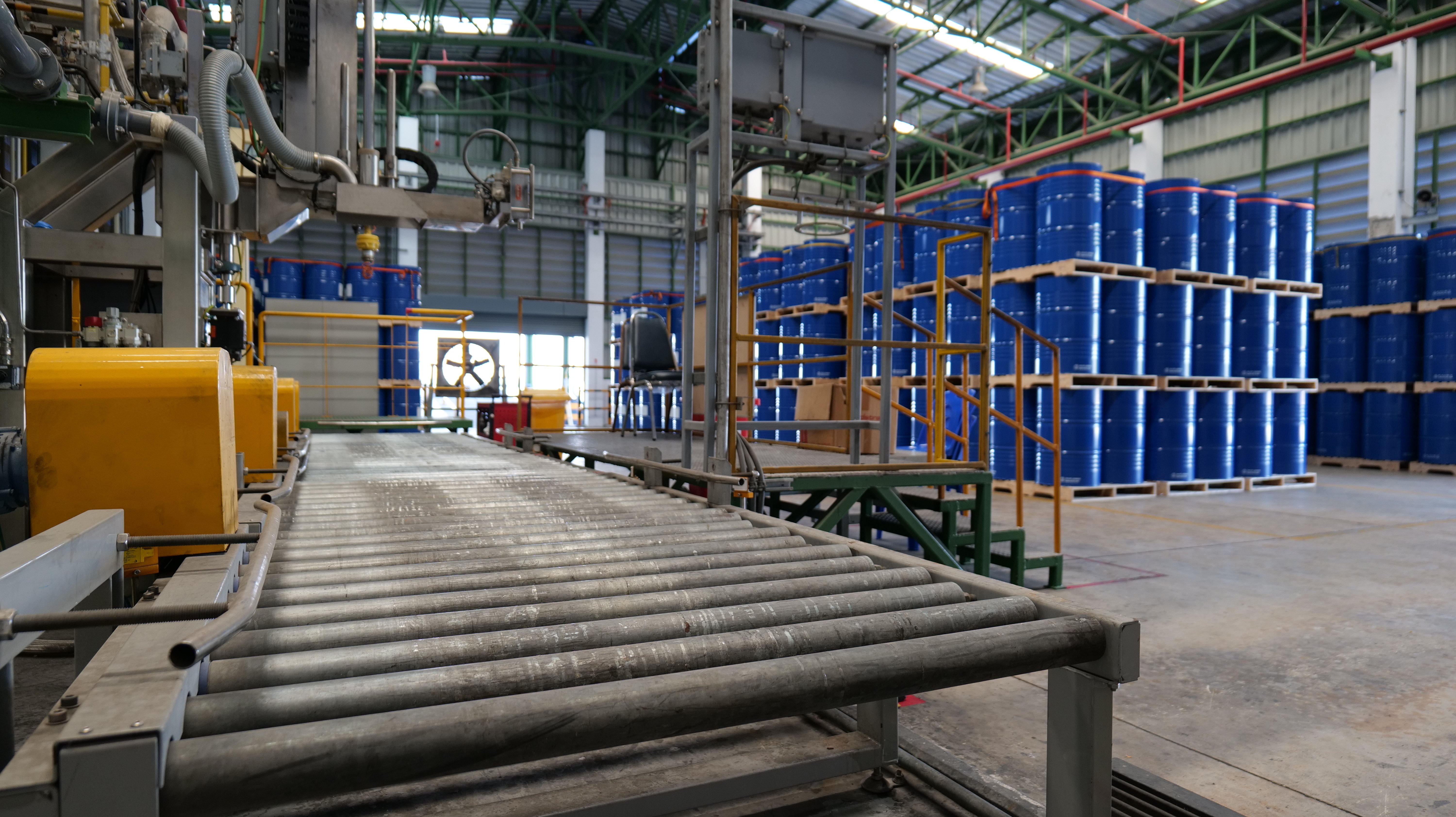 Chemical production line with blue storage drums.